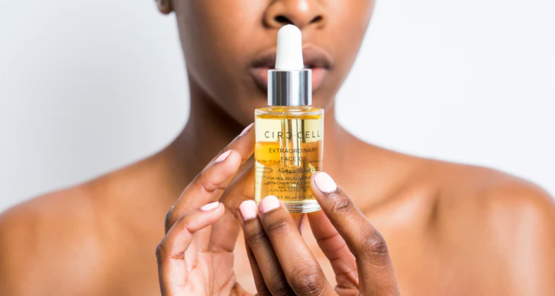 Woman holding skin serum bottle: circulation and skincare in harmony