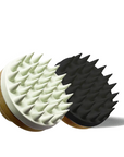 Two massage brushes, one white and one black, on a white background.