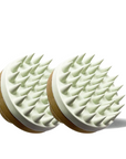 Two scalp massagers with spike-like texture on a white background