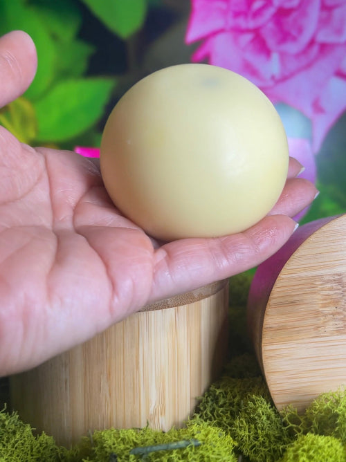 Hand holding a lotion bar with a colorful background