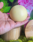 Hand holding a lotion bar with a colorful background