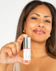 Auve beauty lip oil with model holding it