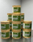 Stack of Harmony body bar containers on a reflective surface with a neutral background