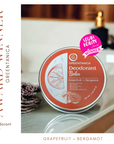Deodorant balm container with 'Greenitanica' branding on a bathroom counter.
