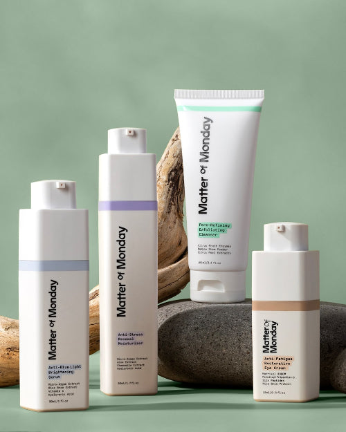 A collection of skincare products including a sunscreen stick, a face wash bottle, a toner bottle, and a face cream bottle, all labeled 'Mother of Monday'.