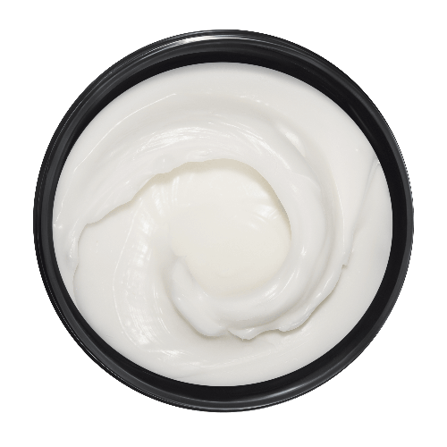 Top view of a container with white cream on a dark green background