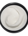 Black container with white cream on a dark background