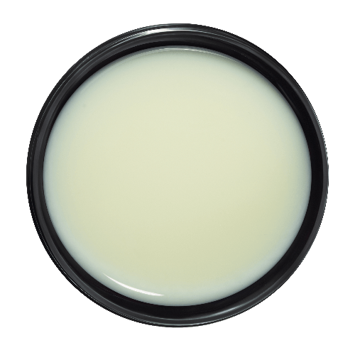 Round container of cream with a black rim on a dark green background