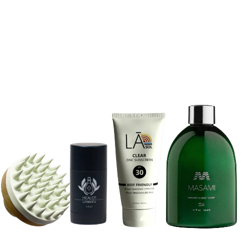 Collection of skincare and grooming products including a brush, stick, tube, and bottle on a white background.