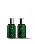 Two bottles of MASAMI branded hair care products, one labeled as shampoo and the other as conditioner, with a dark green color and silver caps.