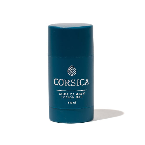 A blue cylindrical container labeled CORSICA GLOW LOTION BAR, 50ml size, with a white leaf logo.