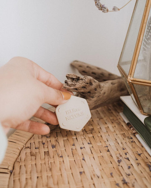 Hand holding Isle de Nature scent coin