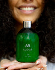 Woman with curly hair holding MASAMI shampoo