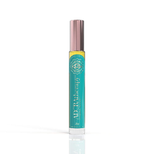 A roll-on perfume oil bottle with a pink cap, labeled 'Chakra 4 Joy' by ADORAtherapy.