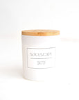 A white candle with a wooden lid and a label that reads 'SoulScape'. The candle is placed against a white background.