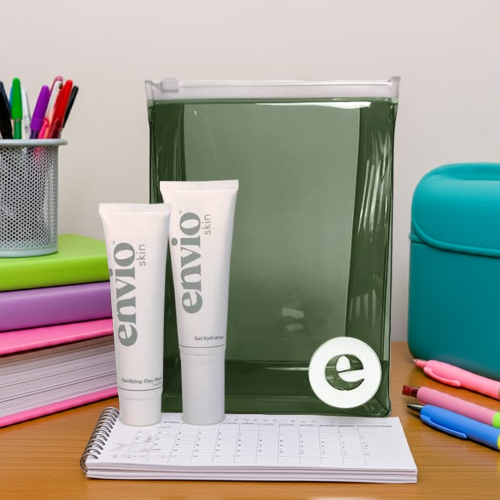 Two Envio skin care tubes on a desk with stationery items.