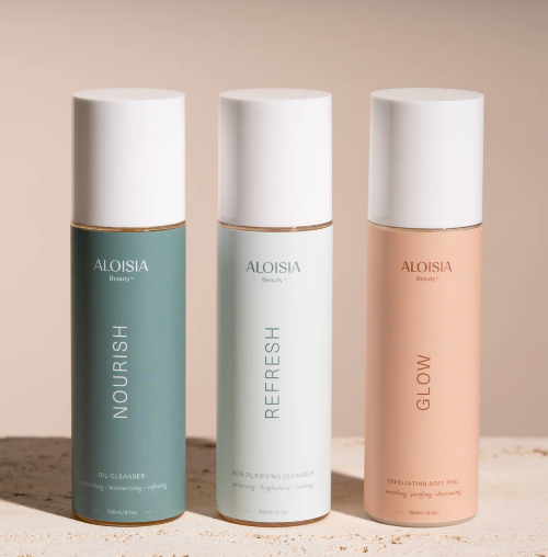 Three Aloisia beauty product bottles labeled 'Nourish', 'Refresh', and 'Glow' on a neutral background.