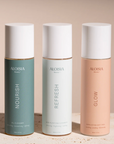 Three Aloisia beauty product bottles labeled 'Nourish', 'Refresh', and 'Glow' on a neutral background.