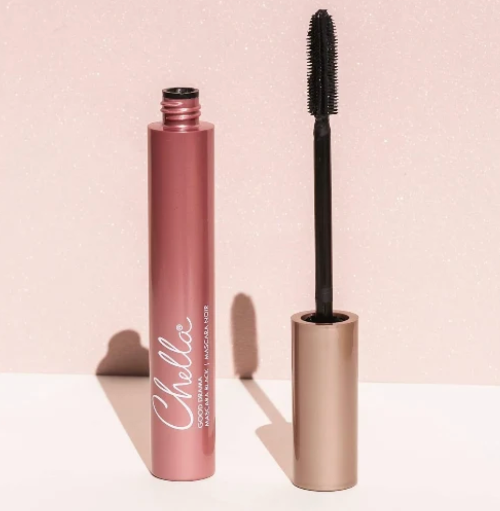Chelle Cosmetics Good Skin Lip Colour in a metallic rose pink tube, shown next to its wand applicator on a light pink glittery background.
