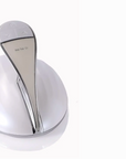 A chrome-finished electric hair waxing device with a round charging base, shown on a plain white background.