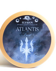 A round tin of Elysian Atlantis Fresh shave soap, featuring a navy blue and light blue watercolor-style label with a white trident graphic and a gold-colored rim, set against a plain white background.