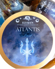 A round tin of Elysian Atlantis Frost premium quality shave soaps, featuring a blue and white icy design with a glowing trident logo and a gold-colored rim.
