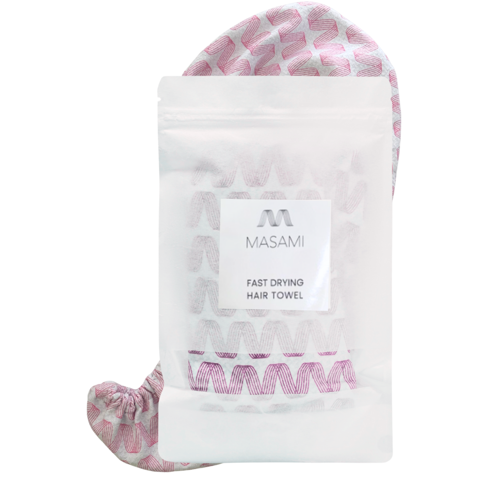 A MASAMI fast drying hair towel in a clear stand-up pouch with a white label, with the pink and white patterned hair towel visible behind and around the package on a white background.