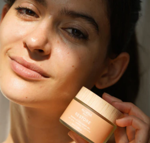 Woman holding a skincare product with a blurred background