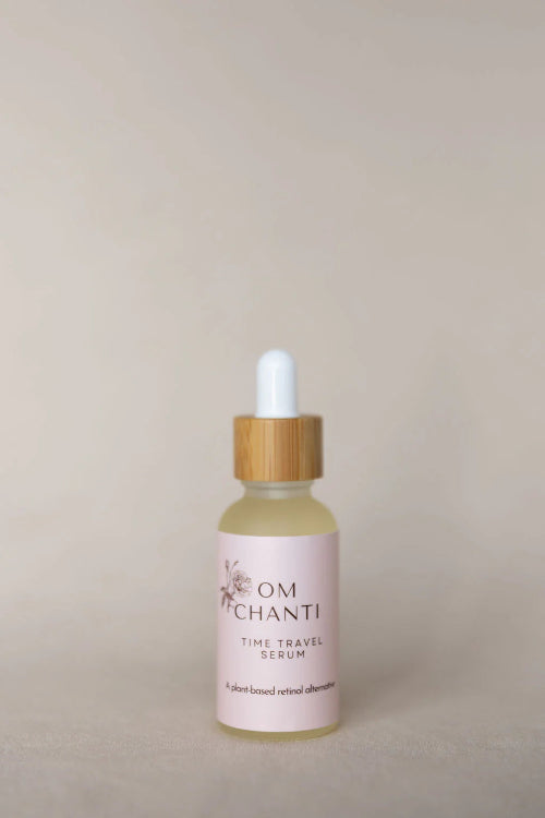 Bottle of Om Chanti serum with dropper on a beige background