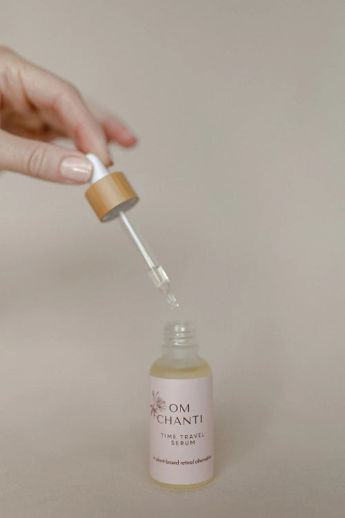 Bottle of 'La Om Chanti' serum with dropper on a beige background